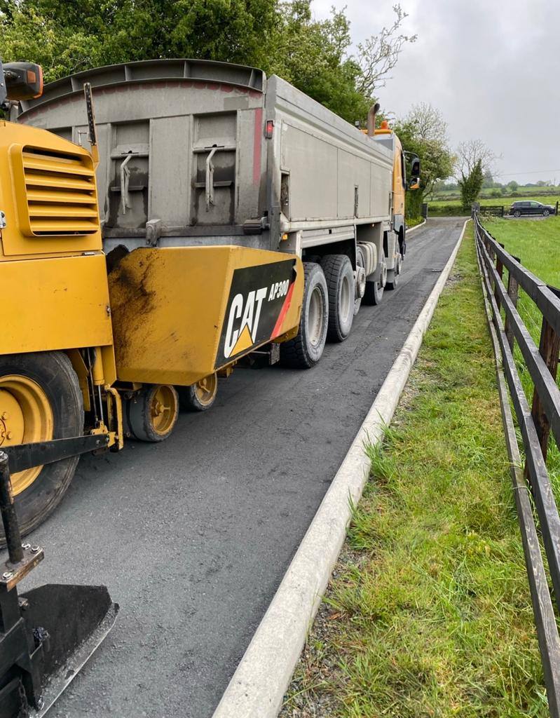 Paver and lorry working along a kerbed lane